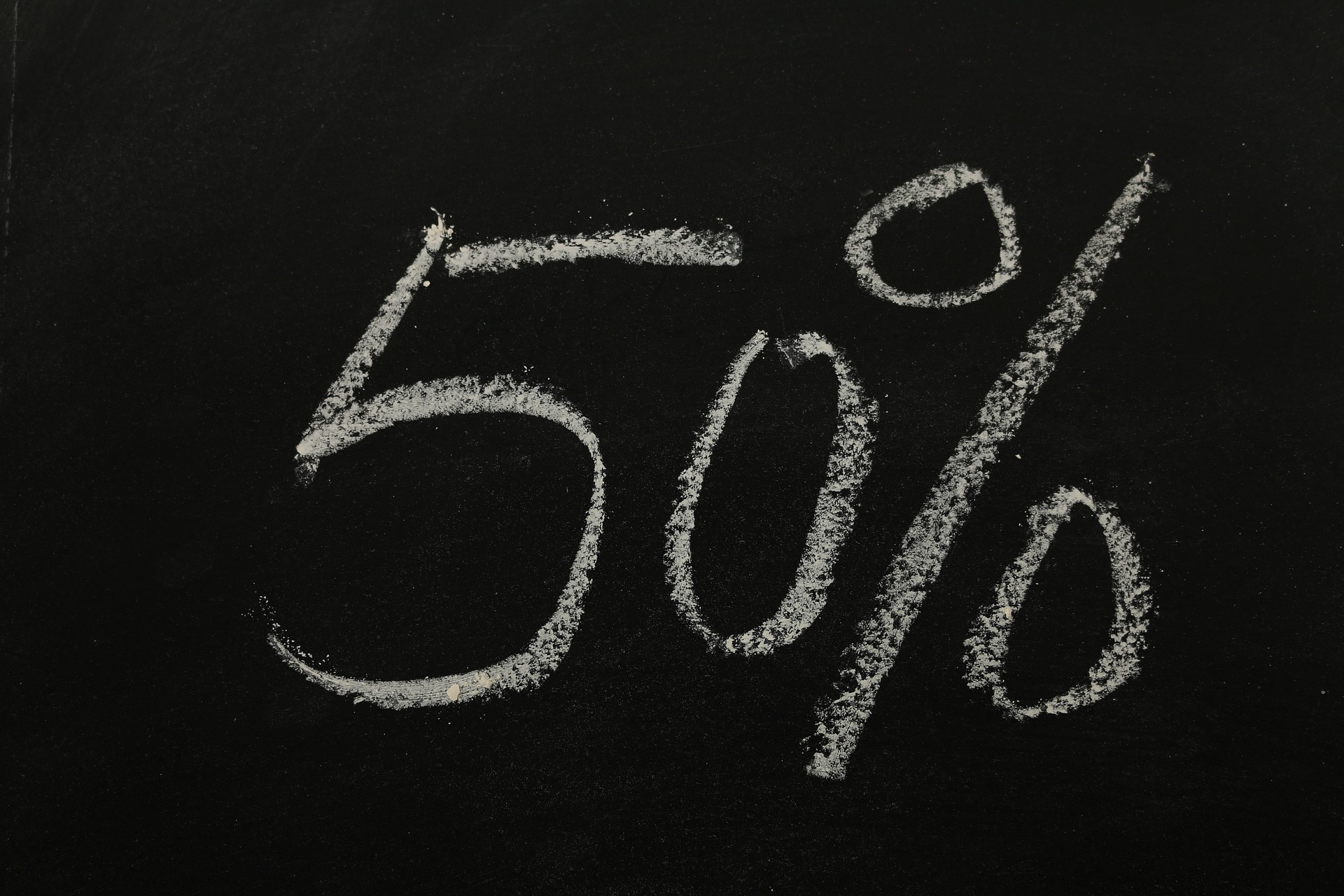 "50%" written with chalk on a blackboard representing loyalty rewards as a marketing strategy tip